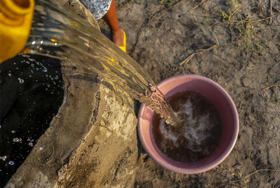 Pouring drinking water from a well in Mozambique