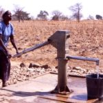 Woman pumping water from a well in Ghana. BGS © UKRI.