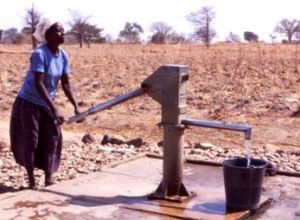 Woman pumping water from a well in Ghana. BGS © UKRI.