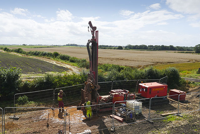 A borehole drilling machine in a muddy field
