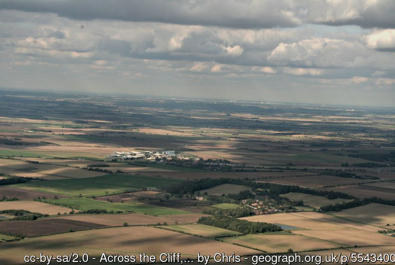 an aerial view over flat, beige and green fields