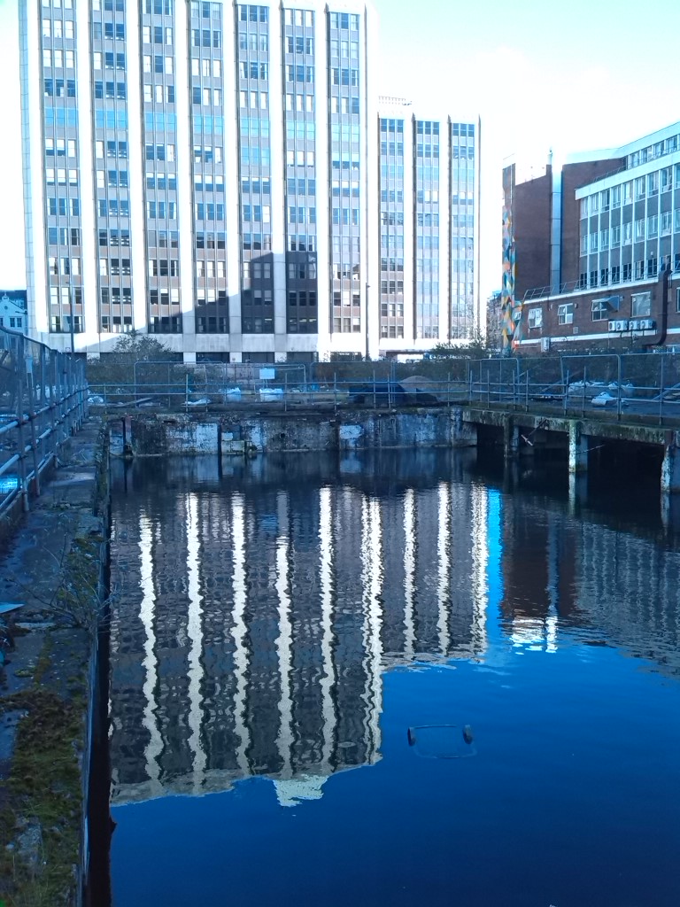 A disused basement of a demolished building that has filled with water