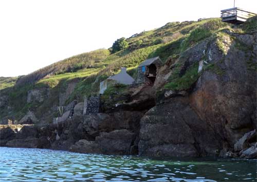 Landslide scar and proximity to the village access road and viewing platform. Note the cave extending under the barn.