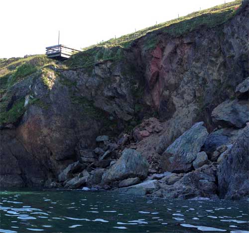 Rockfall to south of May 2012 landslide. Boulders of mica schist derived from the cliff can be seen resting on the rock platform amongst the ruins of the village. The overlying head deposits were also undermined but these have since been removed by rainfall and wave action.