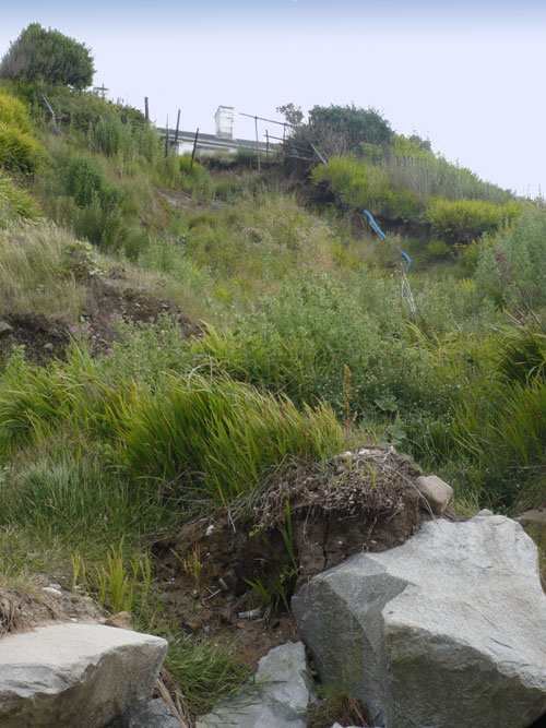 Depression caused by seepage below buildings in Nefyn Bay.