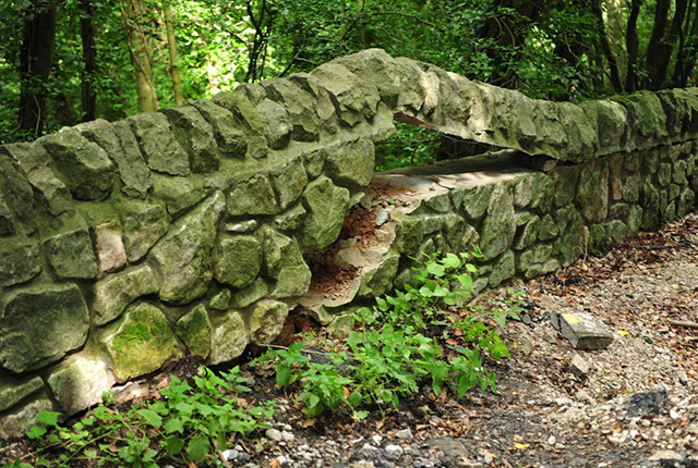 Close-up of damage to a wall adjoining the road (B5056).