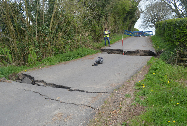 Cracks in the road showing where the ground has dropped and moved laterally.