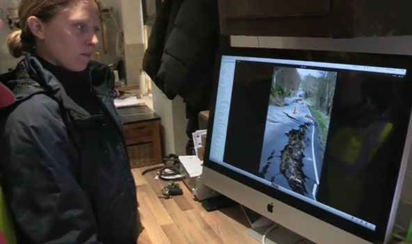 Dr Claire Dashwood of the BGS Landslide Response Team analysing a sequence of photographs showing the gradual development of the landslide along the B6344, east of Rothbury, Northumberland.