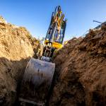 Mini Excavator. Excavator digs the foundation for the house. Photo credit Avalon_Studio.