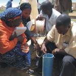 Four people evaluating the yield of a borehole at a BGS-run training course in Nigeria