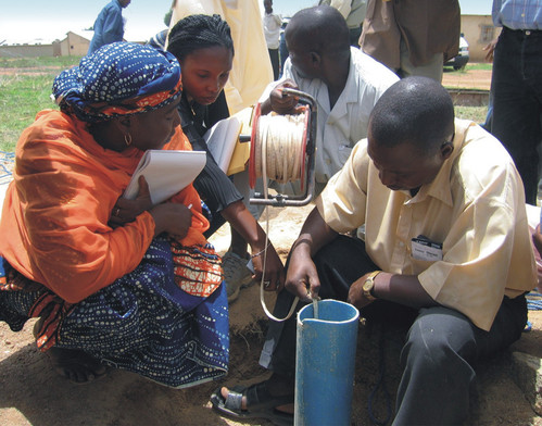 Four people evaluating the yield of a borehole at a BGS-run training course in Nigeria