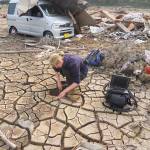 Hannah Evans digging holes to analyse tsunami sediments.