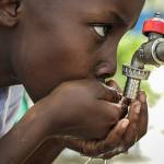 Young boy drinking water from tap, Tanzania. Photo by Chaucharanje, Pexels