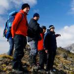 Five peopl in outdoor gear standing on a rocky hilltop