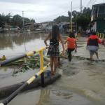 Four people trying to cross a flooded street