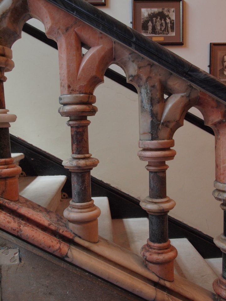 A cose up of a carved balustrade made from pinkish white alabaster