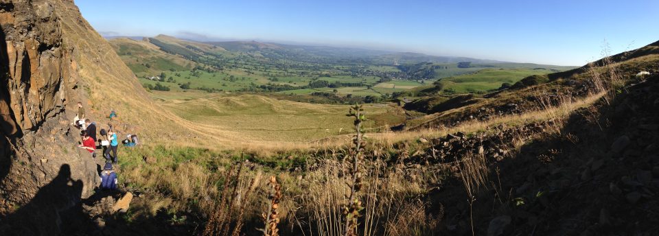 A pnormic view down a valley rocks on either side with
