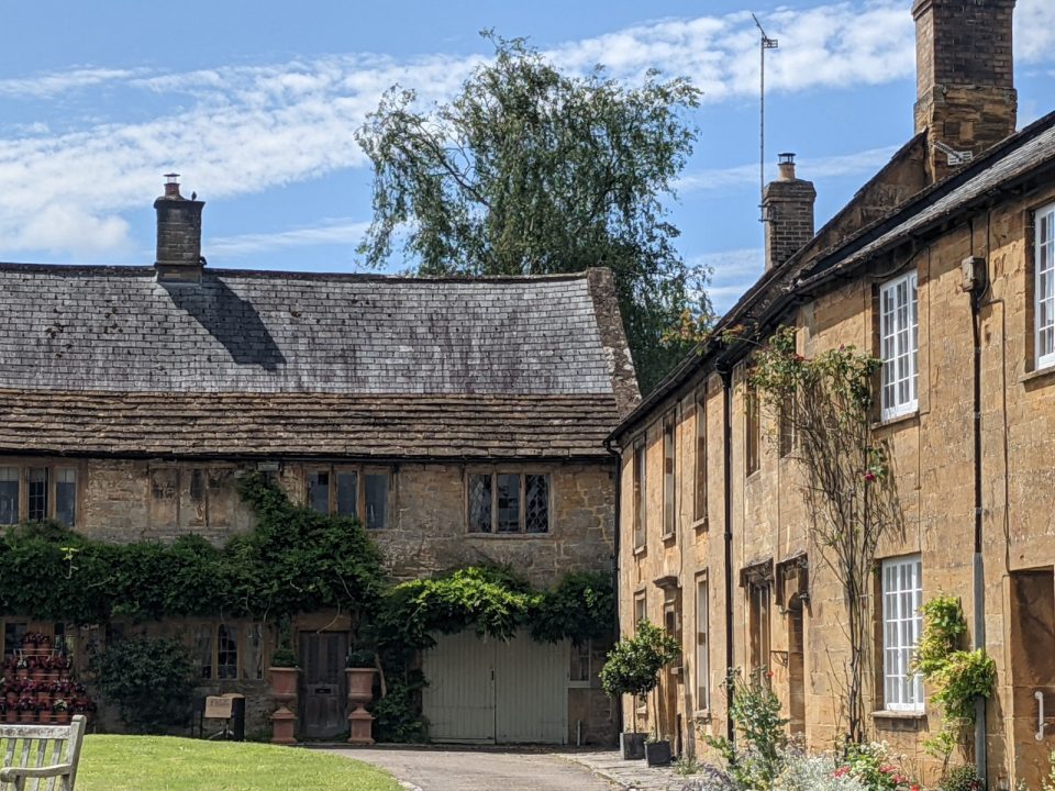 Cottages built of a golden-coloured stone on a clear sunny day