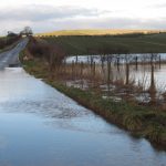 A flooded road and field