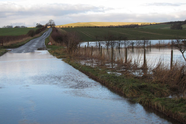 A flooded road and field