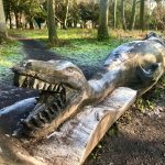 Dinosaur carved into a fallen tree at Highlands Park, Nottingham