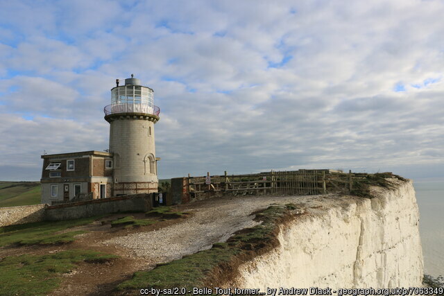 A lighthouse on the edge of a white chalk cliff