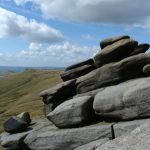 A weathered pile of rocks in the foreground with a gently sloping hill behind