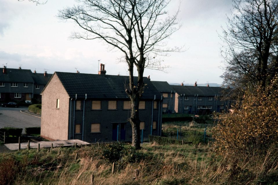 A row of terraced houses with boarded-up windows