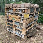 A stack of wood stuffed with sticks, rocks, bricks, dried grass and generally bug-friendly hiding places