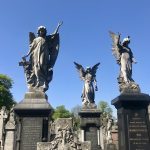 Three gravestones in the form of angels carved from white marble mounted on dark-coloured basalt plinths