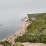 Sandy beaches and white cliffs topped by grassland stretch into the distance
