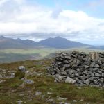 A dry stone wall in the foreground with mountains in the background