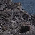 a circular, bowl-like depression in grey rock