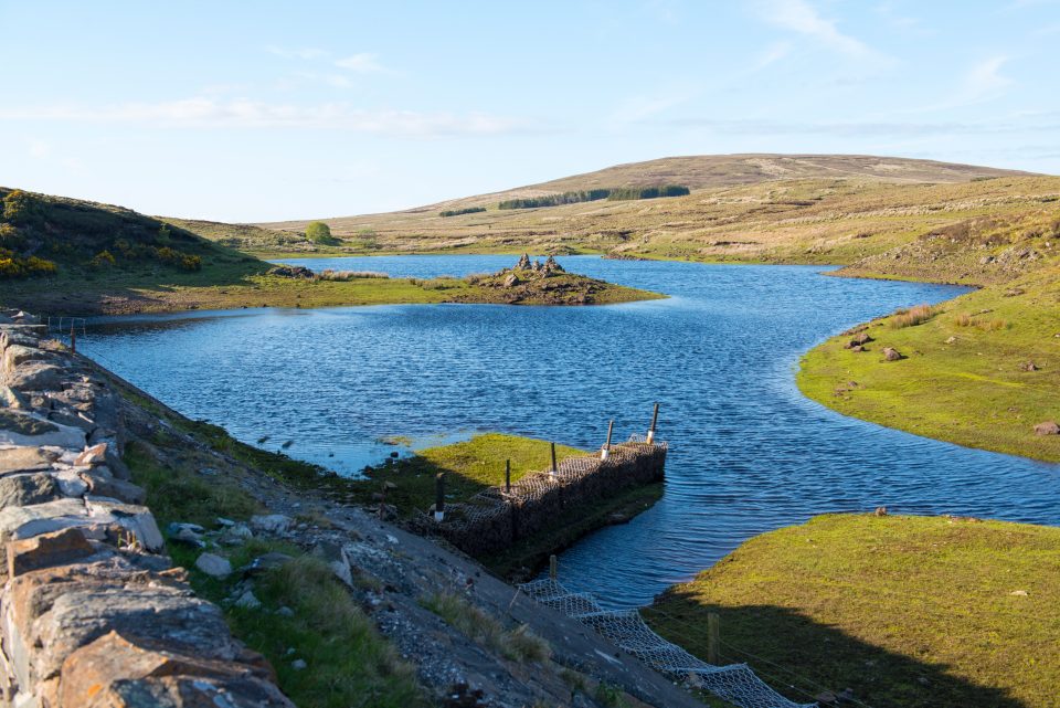 A blue lake amongst low green hills