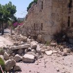Earthquake damage on the Greek island of Kos in 2017. Rubble lies in a street that has fallen from a semi-ruined building.