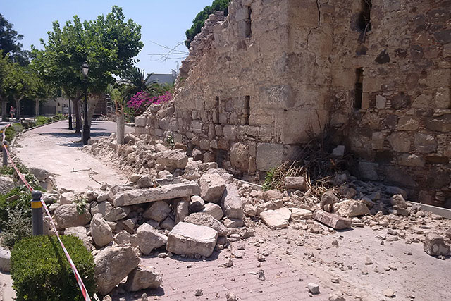 Earthquake damage on the Greek island of Kos in 2017. Rubble lies in a street that has fallen from a semi-ruined building.