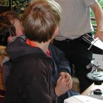 Children looking at thin-section with a microscope. Source: BGS © UKRI