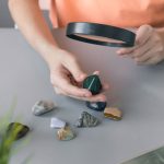 Child looks at his collection of semiprecious stones with magnifying glass. © iStock.com/Mila Naumova