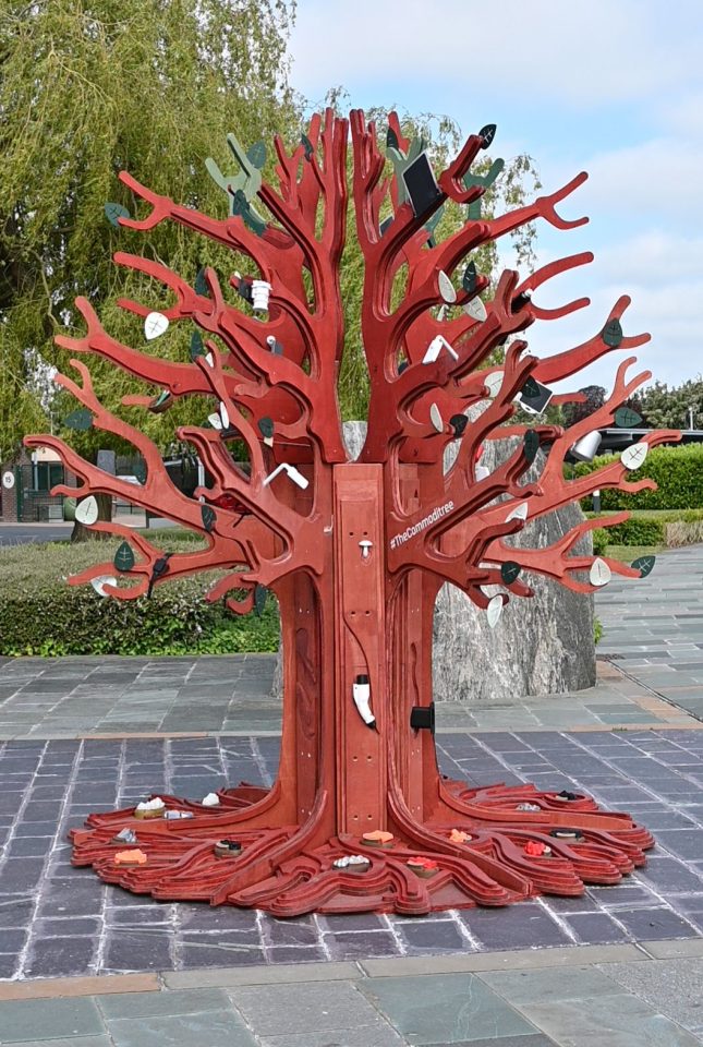 A wooden tree sculpture adorned with items from modern life. Commoditree BGS © UKRI.