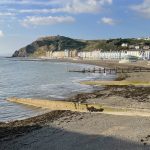 View of Constitution Hill from the pier on Aberystwyth promenade. Note the breakwaters and groynes that intersect the beach and reduce longshore drift, and the cliff railway, which is the longest in Britain. © Melanie Leng.