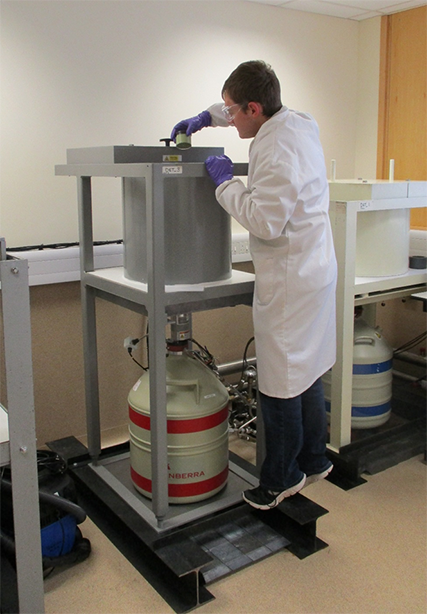 A man in a white lab coat uses a piece of laboratory equipment