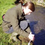 A woman taking samples from a stream