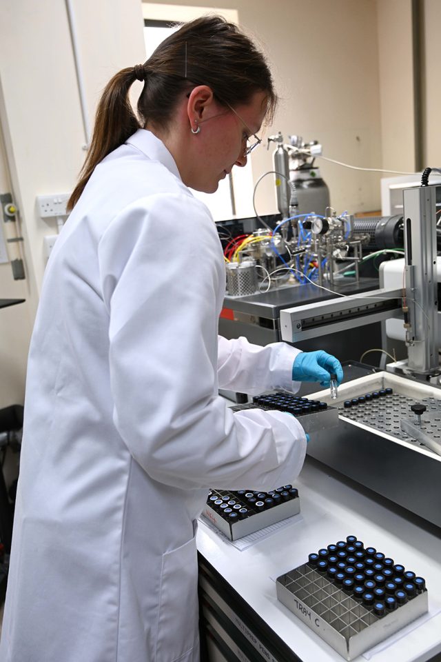 Kotryna Savickaite loading sample vials into the hot block for stable-isotope mass spectrometry. BGS © UKRI.