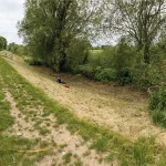 The flood embankment: Photo of ERT survey over the badger sett. The burrow entrances are hidden in the long vegetation and extended to the fence on the left-hand side. BGS © UKRI.