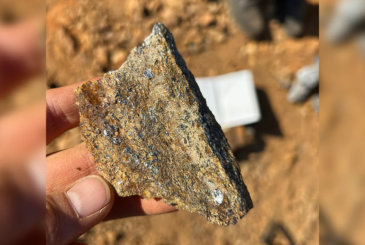 Sand coloured stone with clear grey specles of graphite.