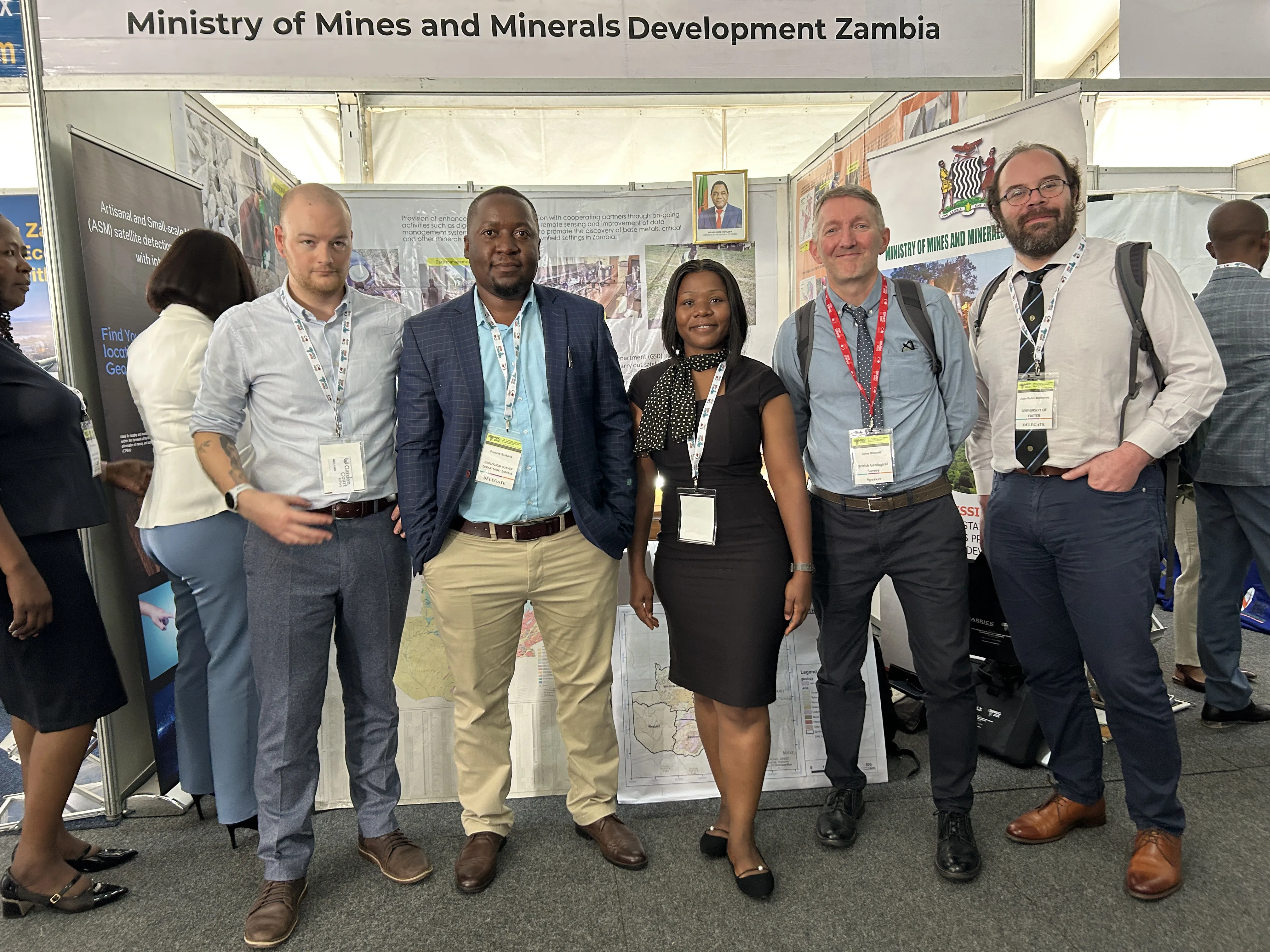 5 UK and Zambia critical minerals staff standing in front of the Ministry of Mines and Minerals Development Zambia stall.